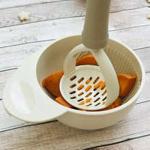 Load image into Gallery viewer, Hand masher is used to mash steamed sweet potato in masher bowl. Baby's first food is in masher bowl.