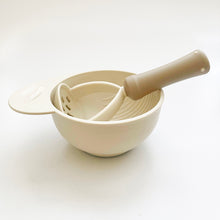 Load image into Gallery viewer, Hand masher in neutral colors is in a mashing bowl with nonslip base.
