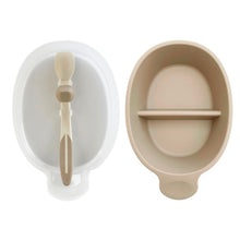 Load image into Gallery viewer, Translucent lid holds stay clean spoon is next to beige 6" long sectioned bowl with a small handle.
