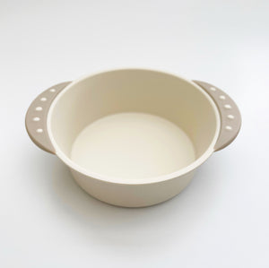 Baby friendly 16 oz bowl has a non slip base, and beige side handles.