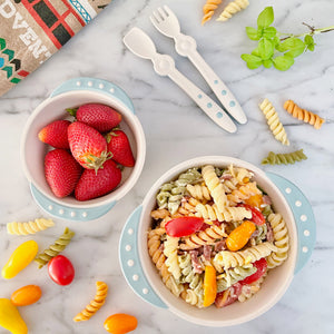 Toddler meal idea. A 16 oz bowl contains vegetable-enriched  pasta, and a 8 oz bowl contains washed strawberries.